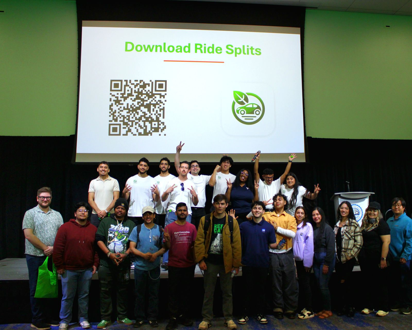 A crowd posing in front of a Download Ride Splits screen